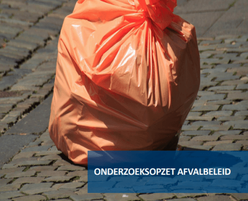 Foto van een oranje vuilniszak op straat.