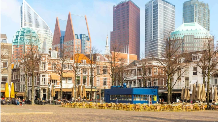 Foto van het Plein in Den Haag met hoogbouw op de achtergrond.