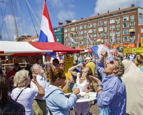 Mensen eten haring op de markt.