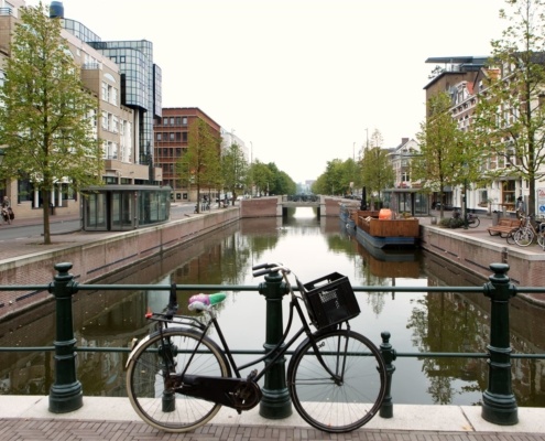 Foto van een fiets op een brug over een gracht in Den Haag.