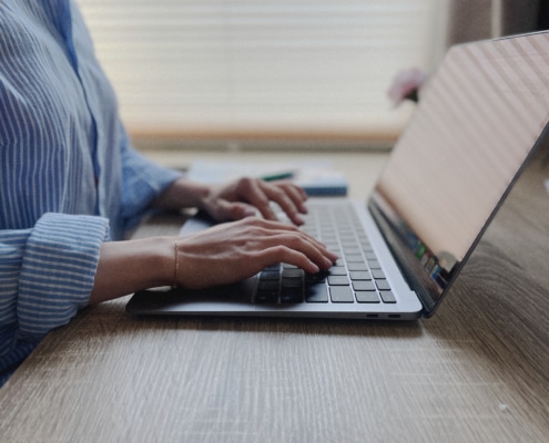 Iemand werkt achter een laptop