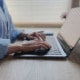 Iemand werkt achter een laptop