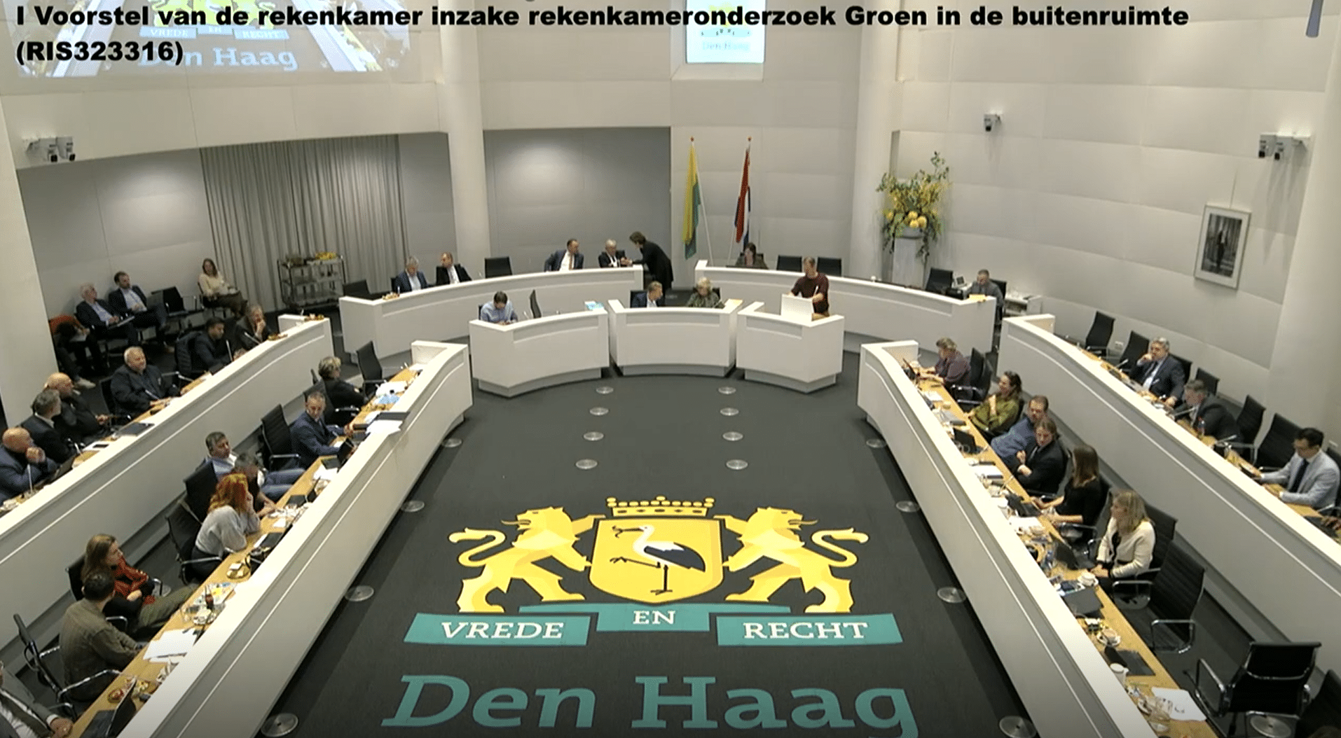 Screenshot van regsitratie van de raadsvergadering. Hierop is de raadszaal te zien.